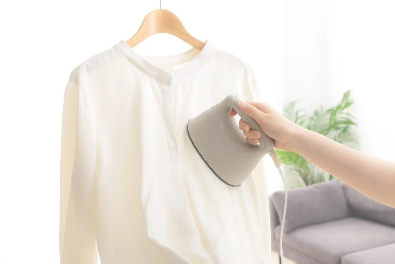 ハンガーにかけたシャツに衣類スチーマーを使用する様子