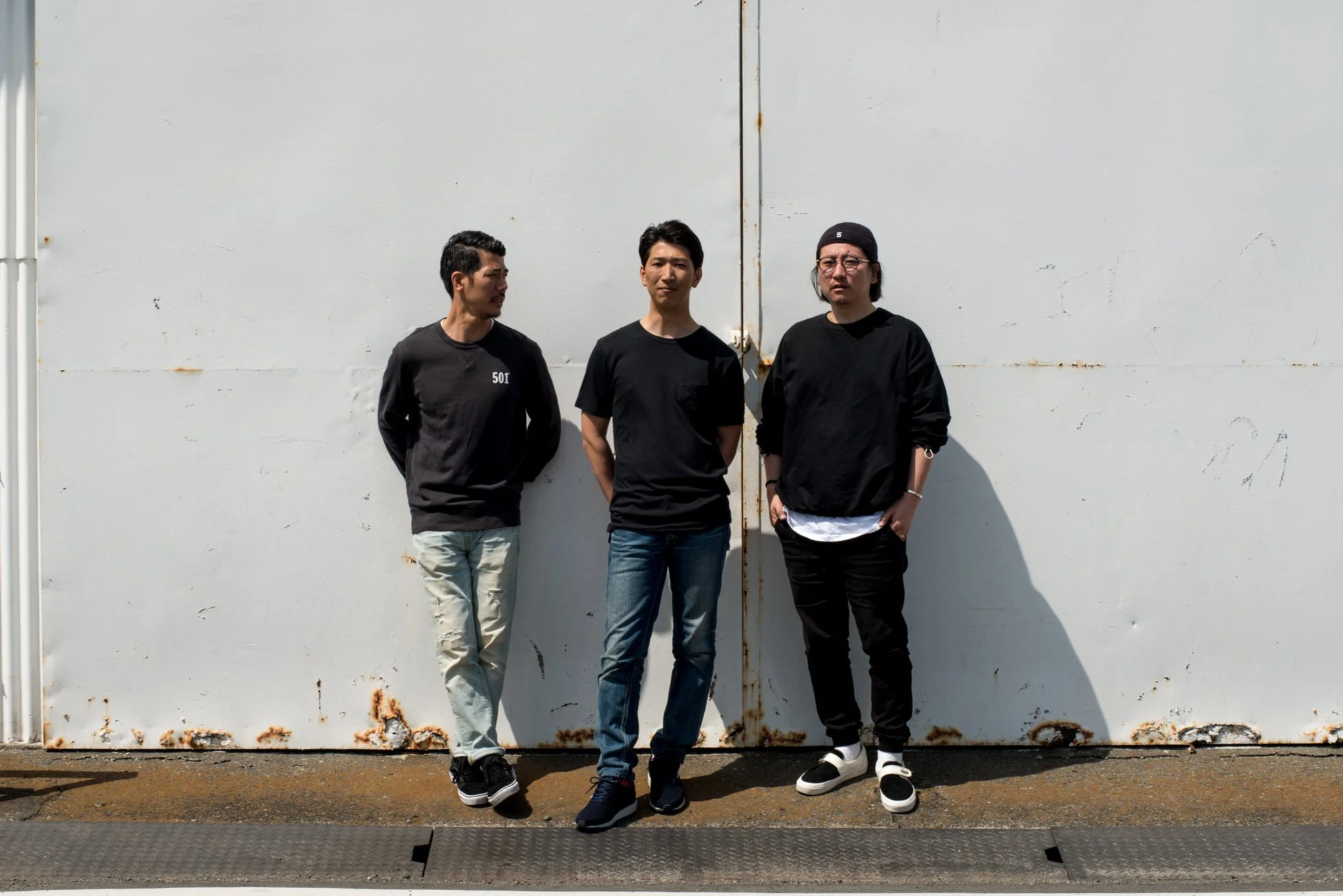 カジュアルな服装の男性3人のグループ写真