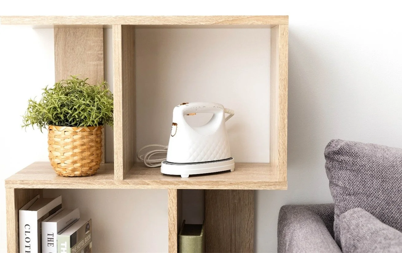 棚に置かれたマットベージュの衣類スチーマーと観葉植物、本